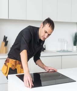 countertop installers fitting ceramic hob onto kitchen countertop